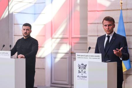 ４日、フランス・パリで開かれた有志国連合の会合後、ウクライナのゼレンスキー大統領（左）と並んで記者会見するマクロン大統領（ロイター＝共同）