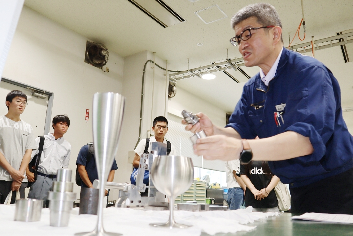 「オープンキャンパス」で、学内の設備や講義内容を紹介する学校職員（右）＝中津市東浜の県立工科短期大学校