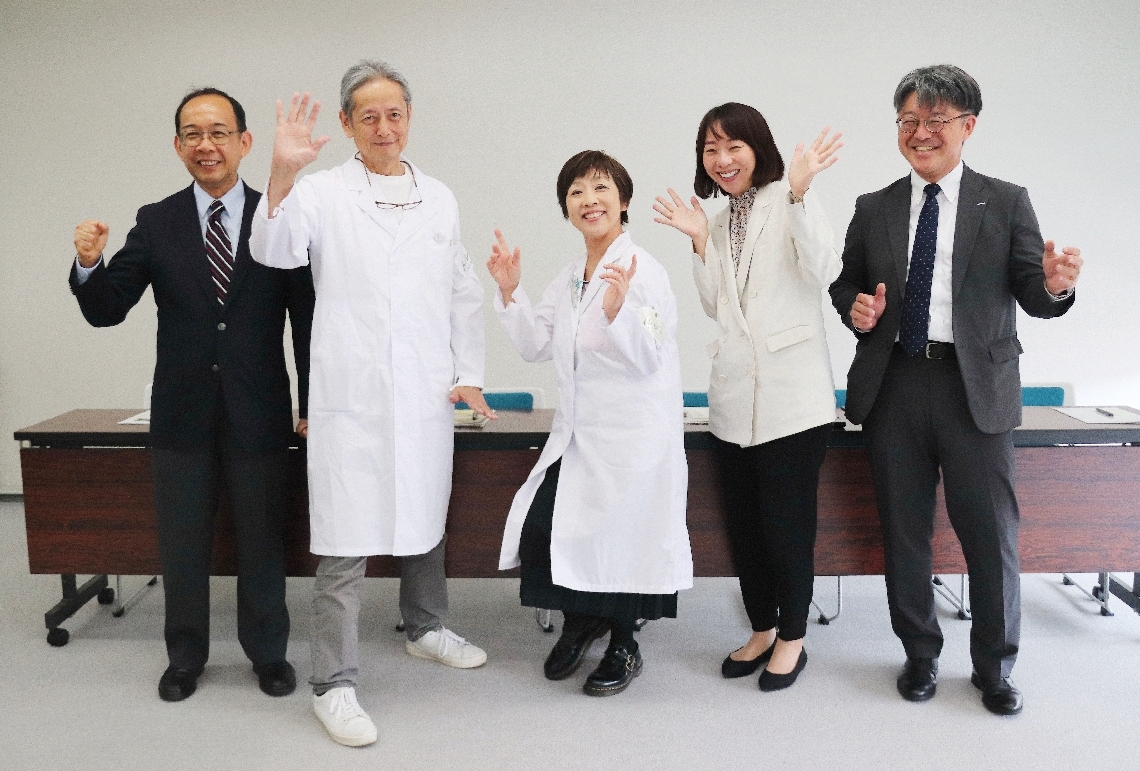 記者会見で喜びを表現する「大分圏清掃整理促進運動会」の八坂千景会長（中央）ら＝１１日、県庁