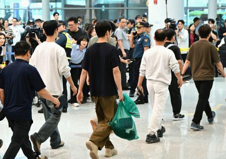 １２日、韓国の仁川国際空港に到着した、米国で拘束されていた労働者ら（共同）