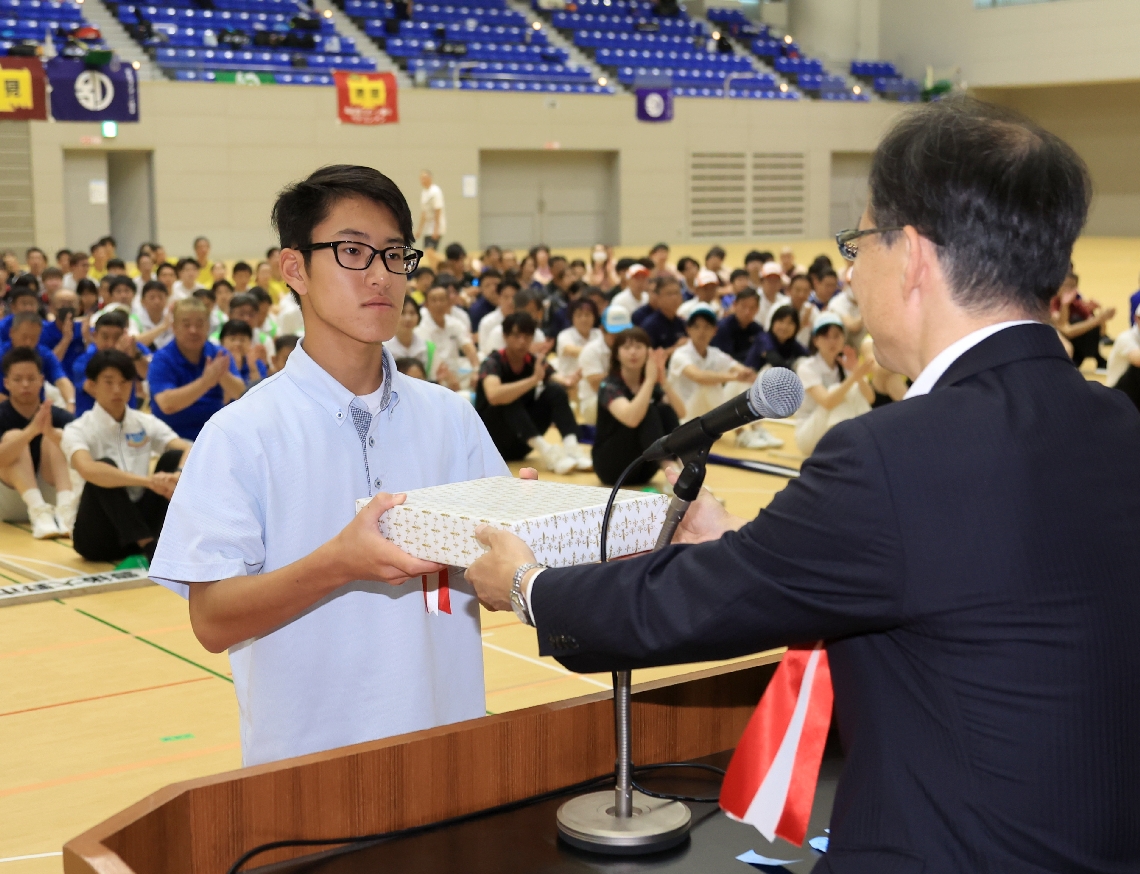 スローガンが採用され、表彰される末房さん（左）