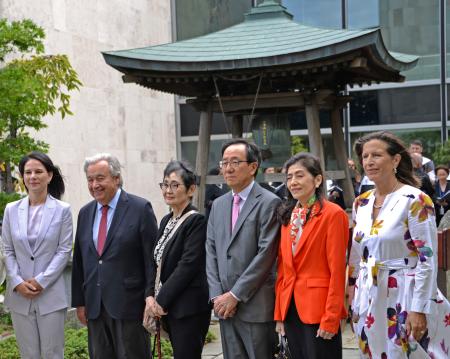 「平和の鐘」の前で記念撮影する、（左２人目から右に）国連のグテレス事務総長、高瀬聖子さん、山崎和之国連大使ら＝１２日、米ニューヨークの国連本部（共同）