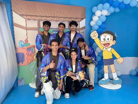 アニメキャラクターのパネルと記念写真に納まる人たち＝１３日、インド・ニューデリー（共同）