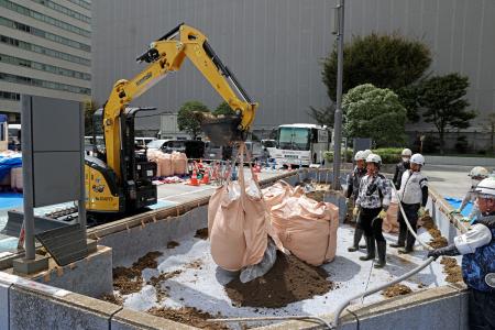 経産省の花壇に入れられる東京電力福島第１原発事故の除染土＝１４日午前