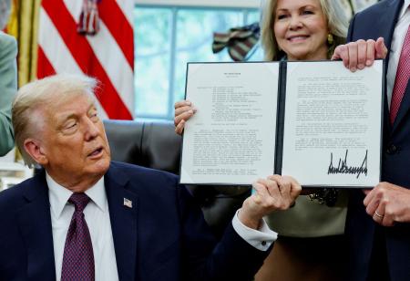 ホワイトハウスで署名した覚書を誇示するトランプ米大統領＝１５日、ワシントン（ロイター＝共同）