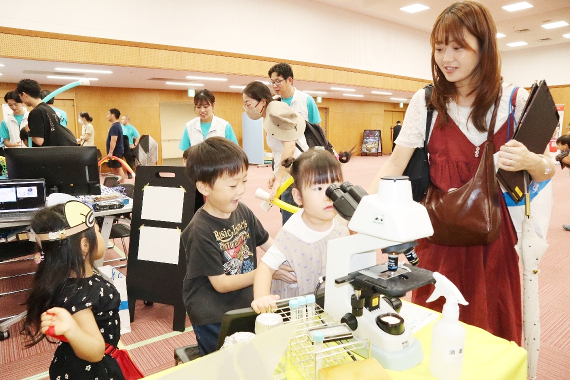 顕微鏡を使って微生物を観察する子どもたち＝２０日、大分市