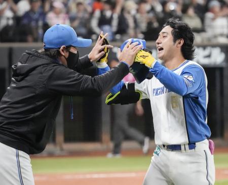 ９回、サヨナラ二塁打を放ち新庄監督（左）に迎えられる日本ハム・浅間＝エスコンフィールド