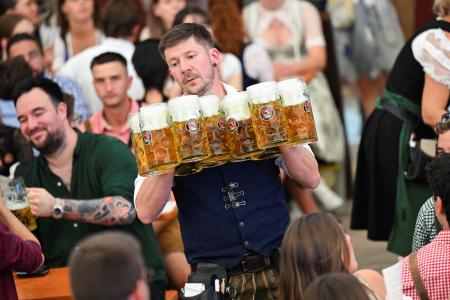ビールジョッキを運ぶウエーター＝２０日、ドイツ・ミュンヘン（ロイター＝共同）