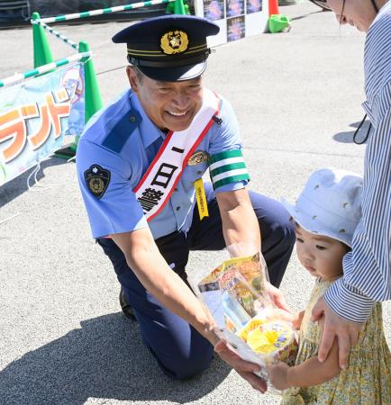 栃木県警小山署の一日署長に就任し、交通安全グッズを配布する神山雄一郎さん＝２１日