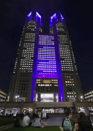 「手話の日」に合わせ、シンボルカラーの青色に照らされた東京都庁＝２２日午後、東京都新宿区