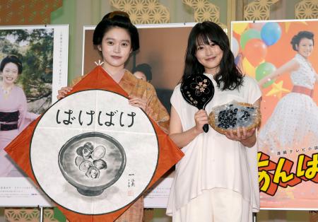 交換したプレゼントを手に写真に納まる高石あかりさん（左）と今田美桜さん＝２３日午後、大阪市中央区のＮＨＫ大阪放送局