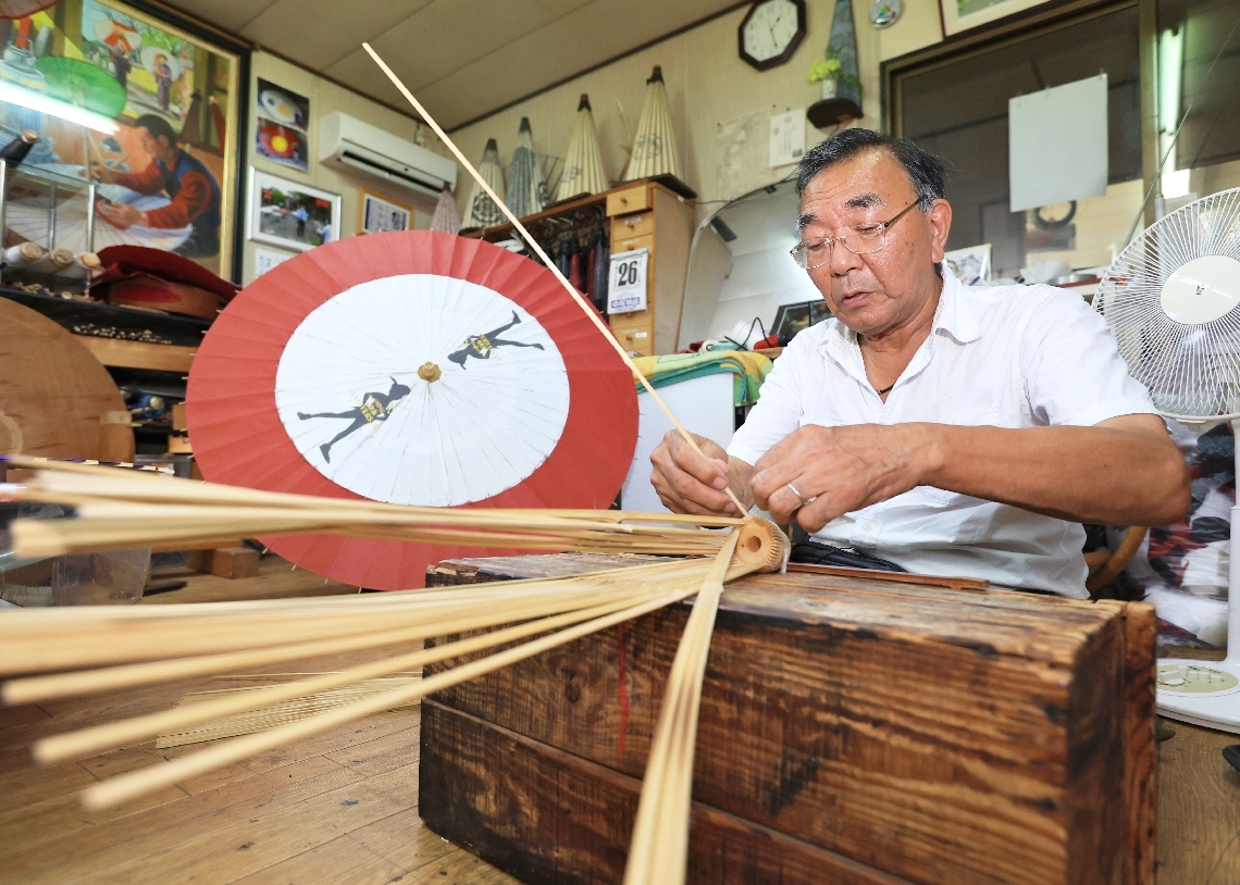 和傘の骨格を組んでいく今吉次郎さん＝中津市鷹匠町