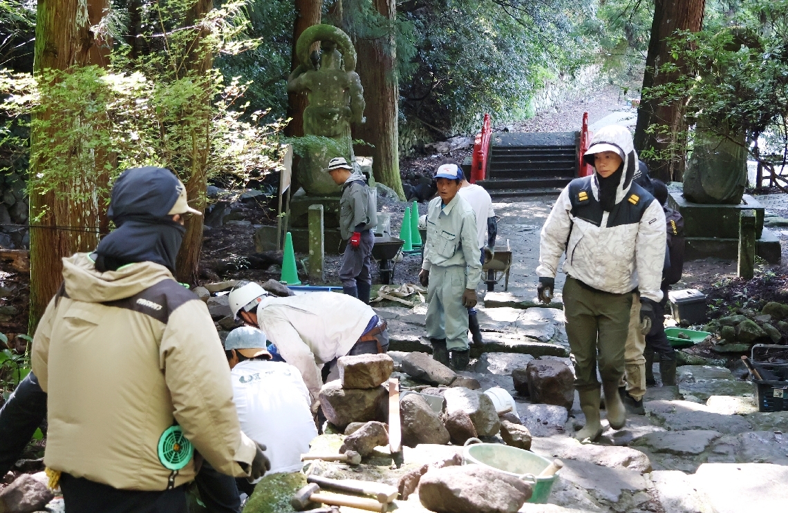 仁王像のそばで作業をする青年部メンバーら