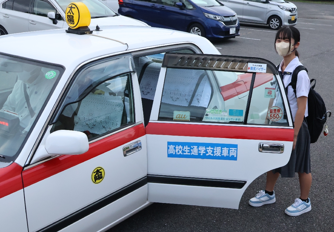 下校時に無料送迎のタクシーに乗り込む平野綾音さん＝豊後高田市の高田高