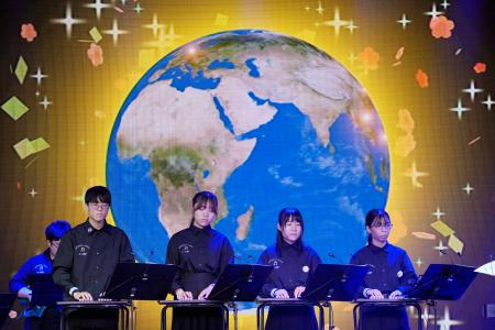 オンラインオーケストラのリハーサルで演奏する学生ら＝２７日午後、大阪市此花区の夢洲
