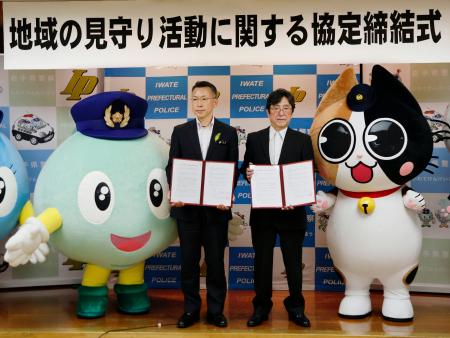 地域の見守り活動を実施する協定を岩手県警と結び、写真に納まる岩手日報会の三浦義之会長（右）ら＝２９日午後、盛岡市