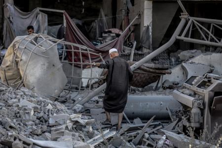 イスラエル軍に破壊された建物のがれきの中から所有物を捜すパレスチナ人＝９月３０日、ガザ北部ガザ市（ゲッティ＝共同）