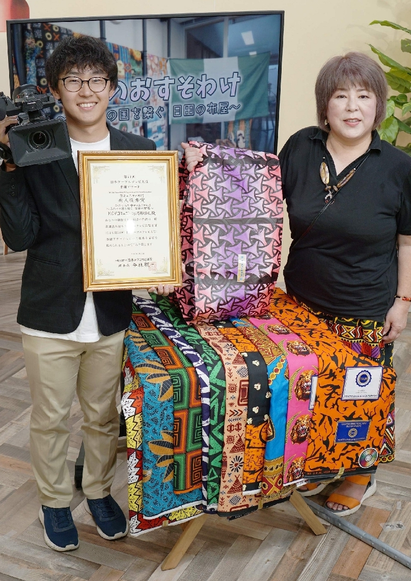 新人優秀賞を受けた末松智宏さん（左）と、番組で取り上げたアフリカ布を販売する小関初美さん＝日田市本町のＫＣＶコミュニケーションズ