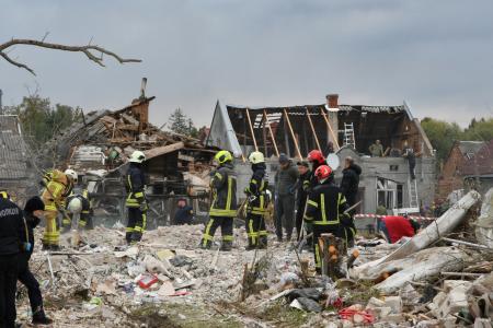 ロシア軍の攻撃で破壊された民家のがれきを撤去する救急隊員ら＝５日、ウクライナ西部リビウ（ゲッティ＝共同）