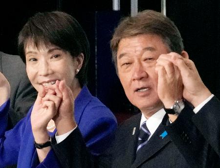 ４日、自民党総裁選後の両院議員総会で手を取り合う茂木前幹事長（右）と高市総裁＝東京・永田町の党本部