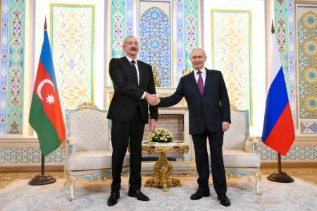 ９日、タジキスタンの首都ドゥシャンベで会談したロシアのプーチン大統領（右）とアゼルバイジャンのアリエフ大統領（タス＝共同）