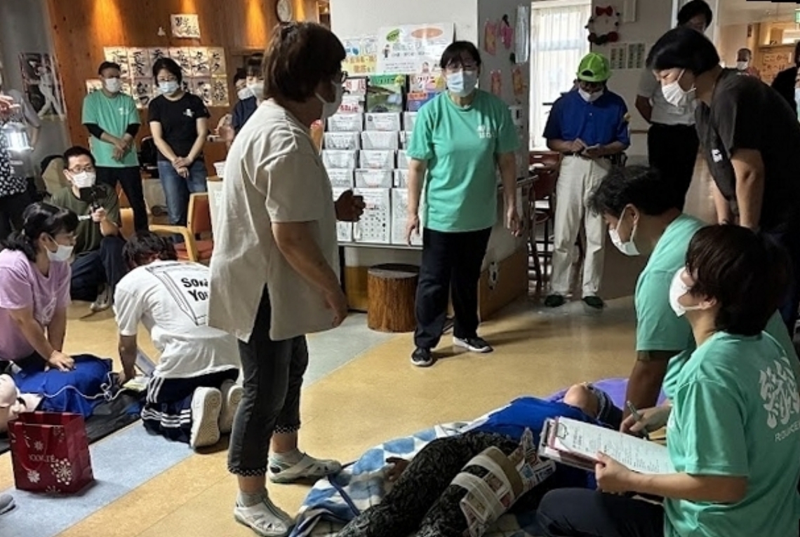 人形を使って入所者を避難させる訓練に取り組む職員