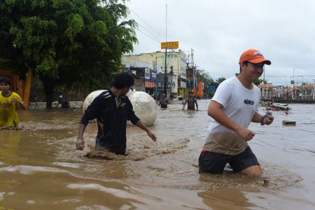 メキシコ東部ベラクルスで浸水した道路を歩く人たち＝１０日（ロイター＝共同）