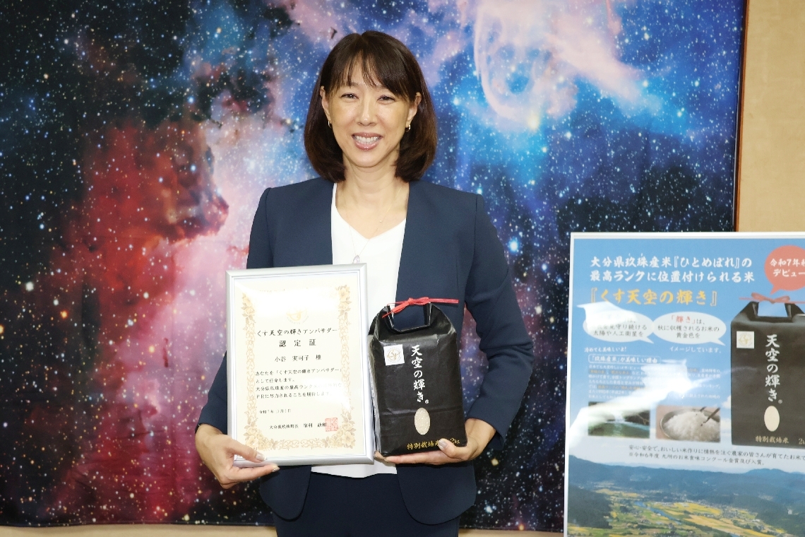 「くす天空の輝き」とアンバサダー認定証を手にする小谷実可子さん＝玖珠町役場