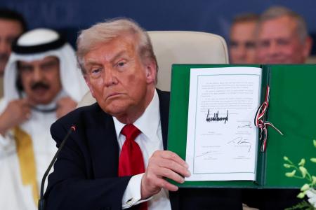 パレスチナ自治区ガザの和平を巡る首脳級会合で関連文書に署名したトランプ米大統領＝１３日、エジプト東部シャルムエルシェイク（ゲッティ＝共同）