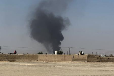 １５日、パキスタンとアフガニスタンの国境地帯で上がる黒煙（ＡＰ＝共同）