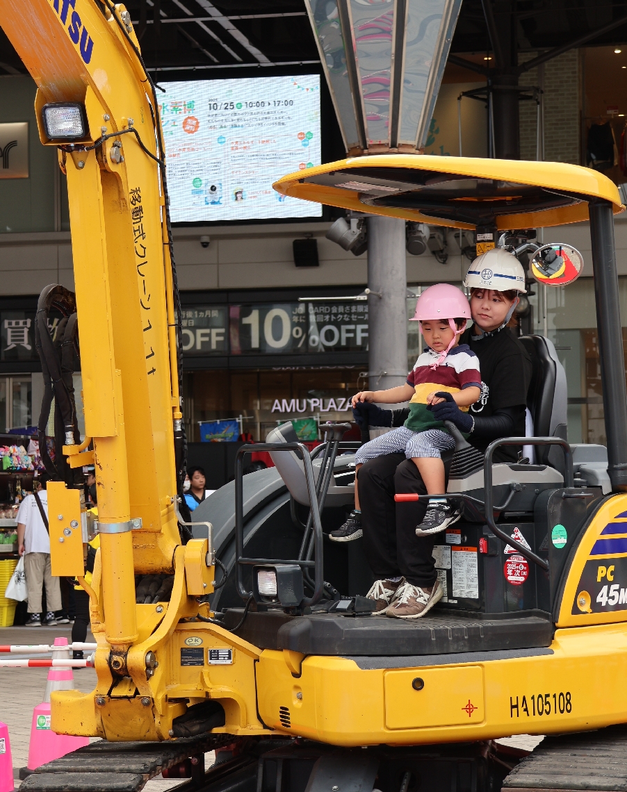 ショベルカーの操作体験をする子ども＝１８日、大分市要町のＪＲ大分駅府内中央口広場