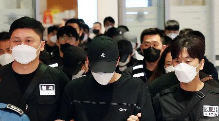 カンボジア拠点のフィッシング詐欺に関与した疑いなどで拘束され、韓国・仁川国際空港に到着した送還者（中央）ら＝１８日（聯合＝共同）