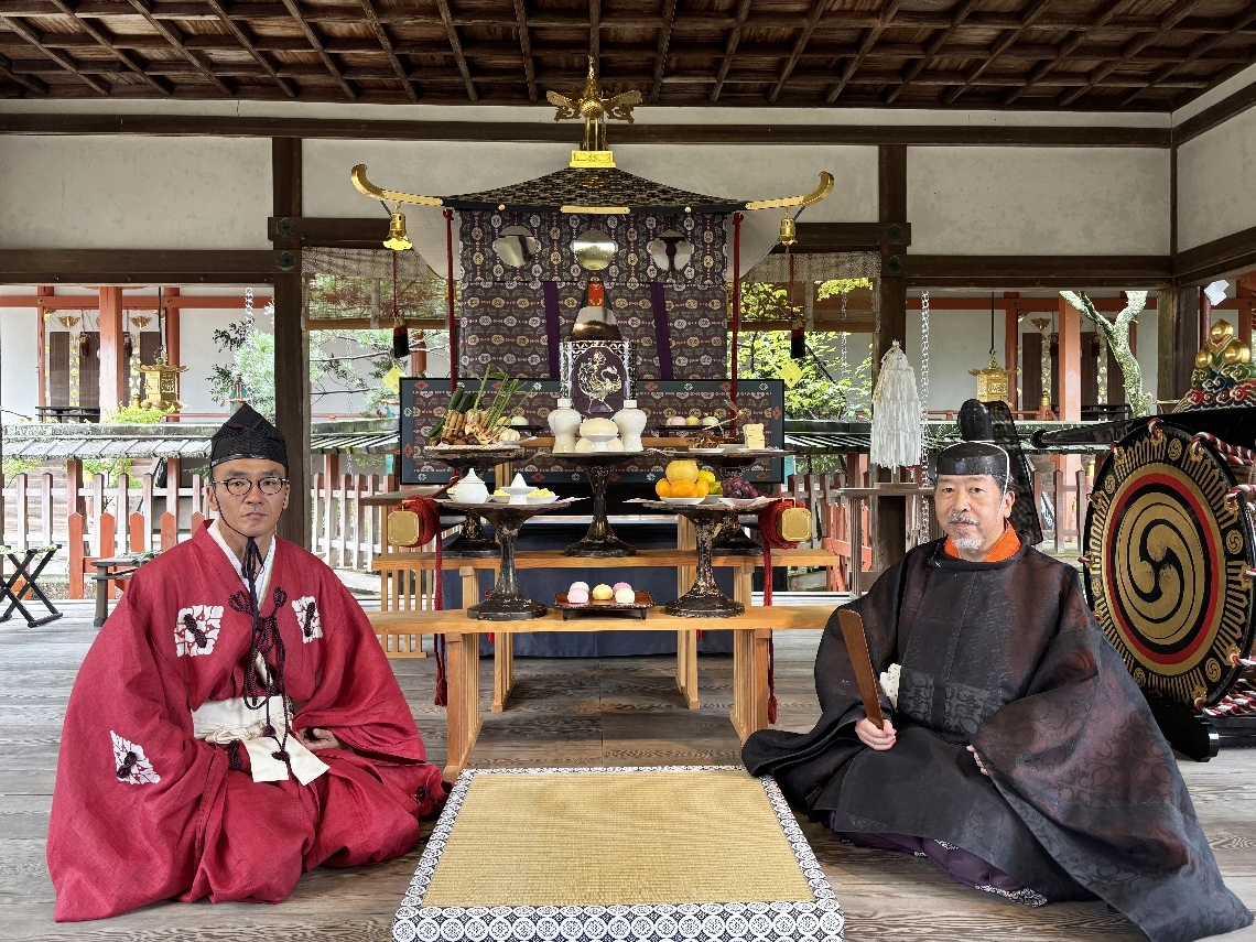 例祭「転害会」のために飾られた御鳳輦を前にする上司延礼宮司（右）とみこし長の樽井宏幸さん＝１０月５日、奈良市の手向山八幡宮