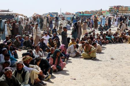 アフガニスタン・パキスタンの国境で、閉鎖措置を受けてアフガンへの帰国を待つ人々＝１８日、パキスタン南西部バルチスタン州（ロイター＝共同）