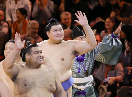 閉会式を終えて手を振り引き揚げる横綱大の里（中央）ら＝１９日、ロンドン（共同）