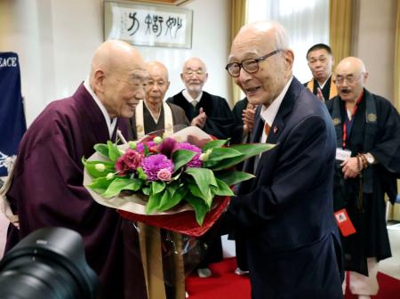 講演後、清水寺の森清範貫主（左）から花束を受け取る被団協の田中熙巳代表委員＝２０日午後、京都市東山区