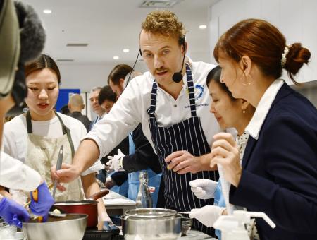 ウクライナ料理を作るエウヘン・クロポテンコさん（左から２人目）と参加者ら＝２１日、東京都千代田区