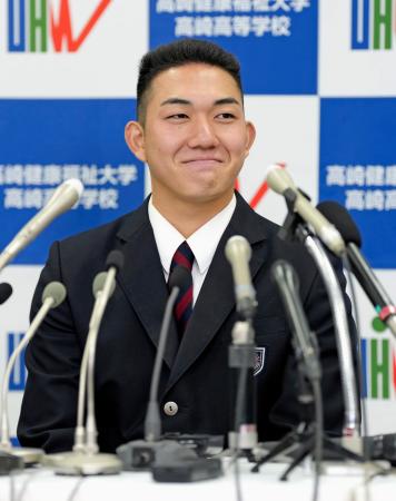 ロッテから１位指名を受け、笑顔で記者会見する健大高崎高の石垣元気投手＝２３日、群馬県高崎市