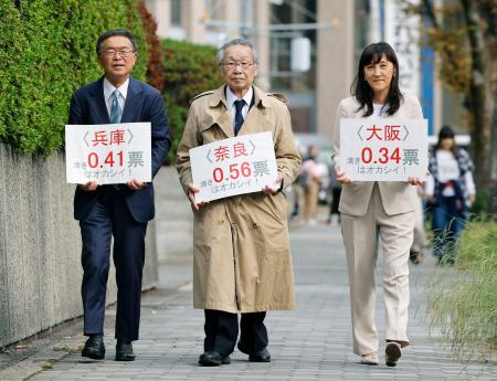 「１票の格差」訴訟の判決で、大阪高裁に向かう升永英俊弁護士（中央）ら＝２４日午後