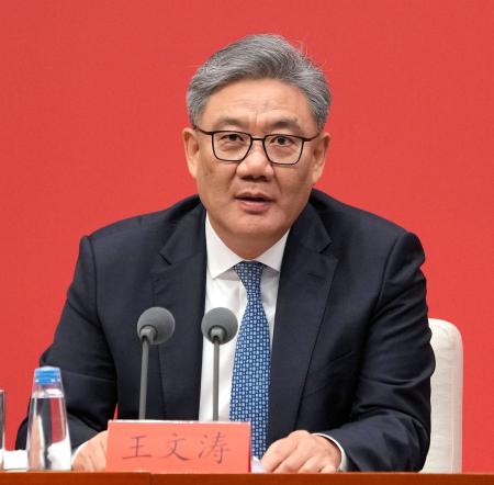 記者会見する中国の王文濤商務相＝２４日、北京（共同）