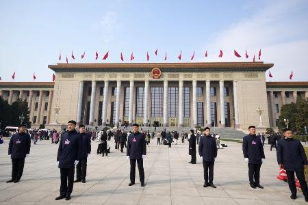 北京の人民大会堂の前で警戒する治安当局者ら＝３月