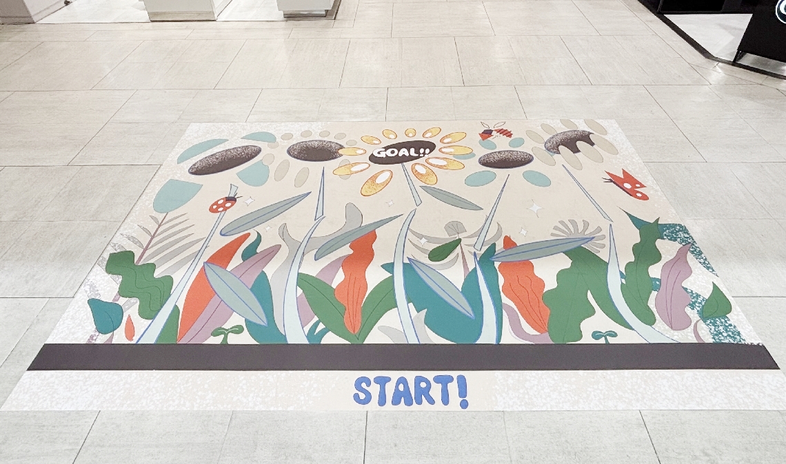 １階案内所前の床を飾る作品「よりみちあみだ」