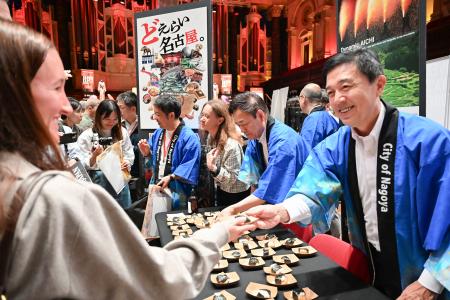 「ジャパンエキスポ」で来場者に天むすを配る名古屋市の広沢一郎市長（右端）＝２５日、オーストラリア・シドニー（共同）