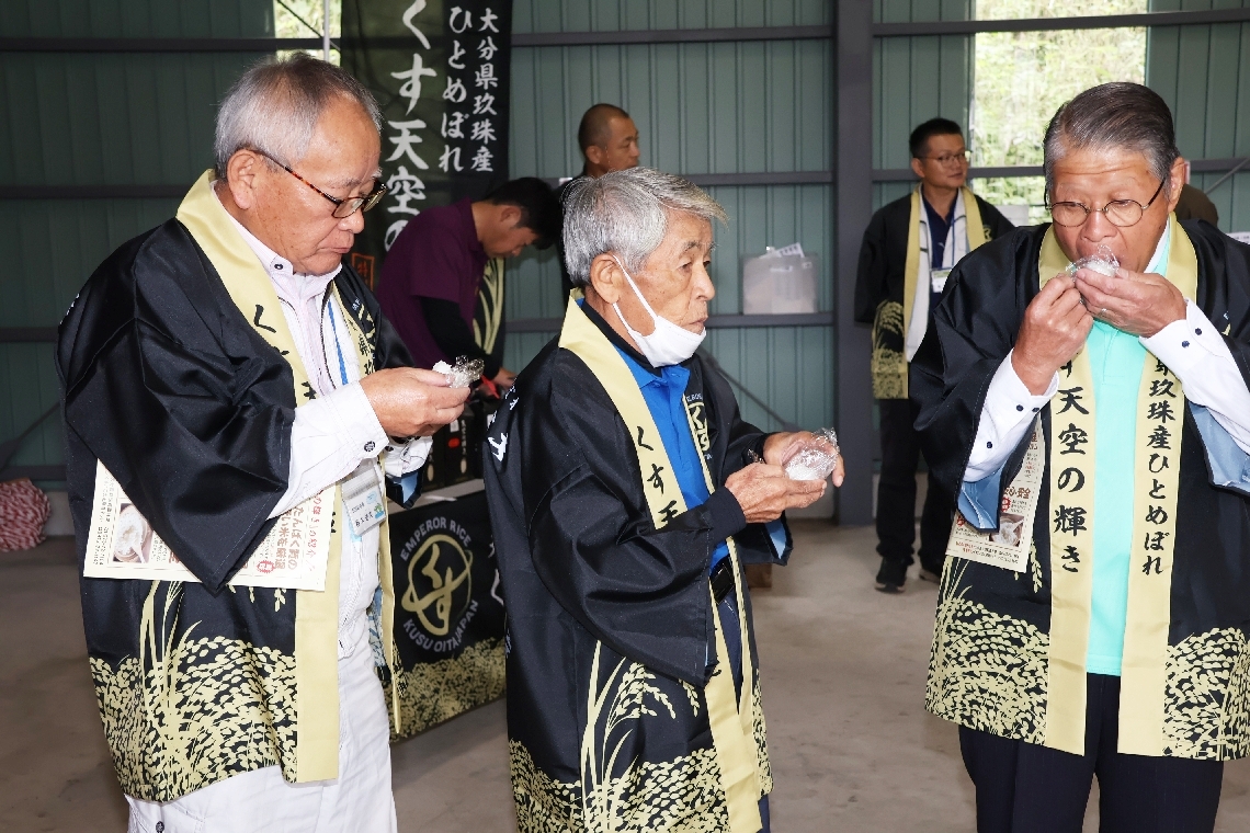 炊きたての「くす天空の輝き」を試食する生産者ら