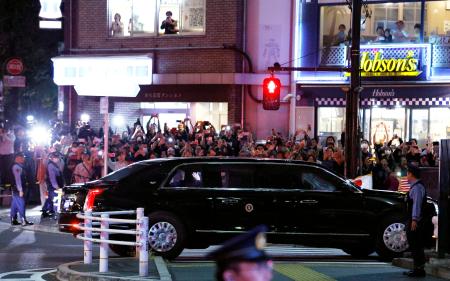 天皇陛下との会見のため皇居へ向かうトランプ米大統領を乗せた車。沿道では大勢の人がスマートフォンを向けていた＝２７日夜、東京都港区