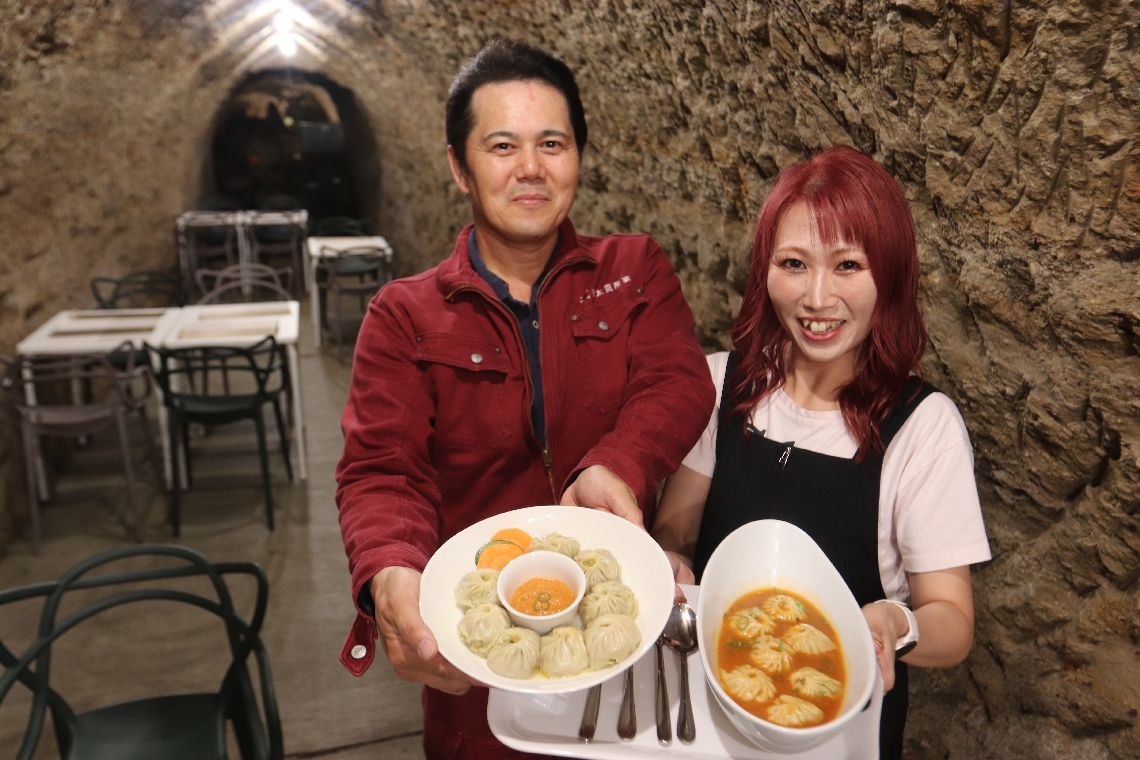 防空壕を利用したネパール料理店。オーナーの園田高太郎さん（左）＝大分市賀来