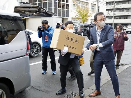 「サクセス観光」事務所からの押収物を運ぶ北海道警の捜査員＝２３日、札幌市中央区