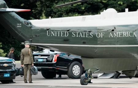 トランプ米大統領を乗せた大統領専用ヘリ、マリーンワンのそばで「核のボタン」とみられるかばんを持ち待機する米軍関係者＝２９日午前、東京都港区の赤坂プレスセンター