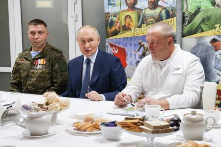 ウクライナ侵攻で負傷したロシア兵らが療養する病院を訪れたプーチン大統領（中央）＝２９日、モスクワ（タス＝共同）
