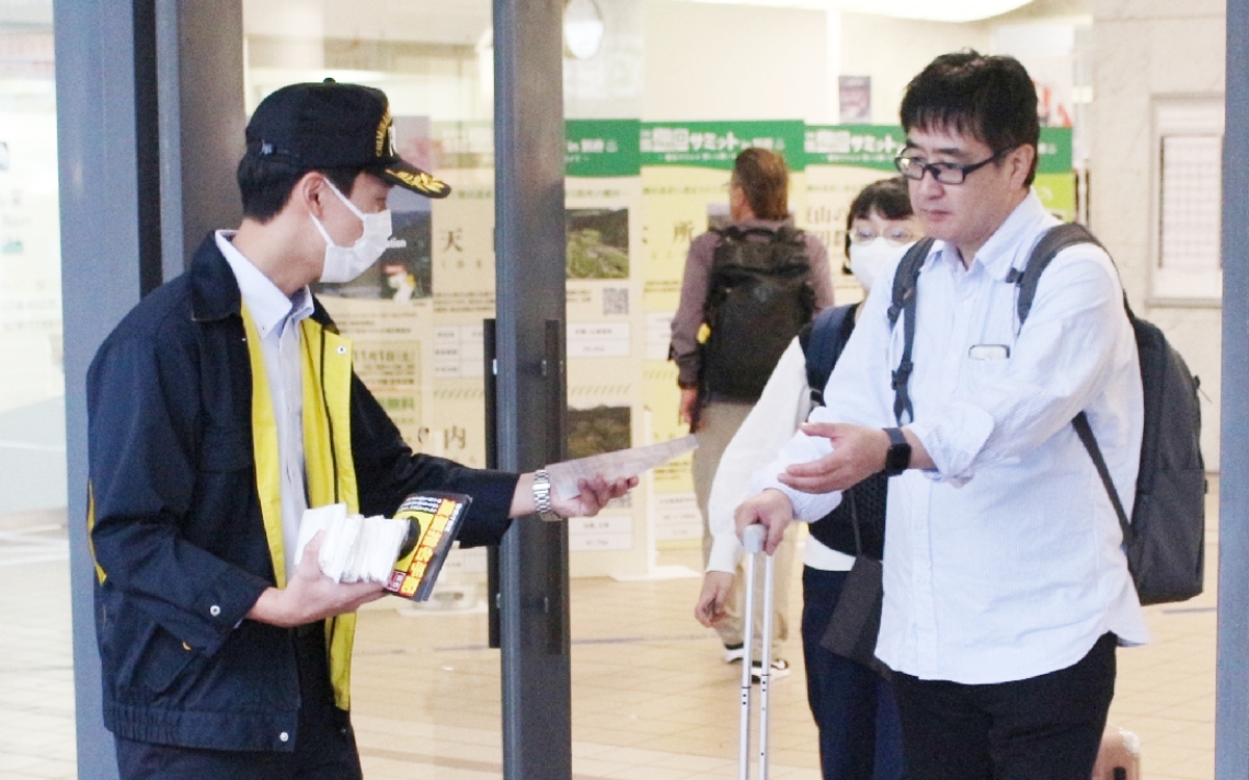 チラシを配り、情報提供を求める別府署員（左）ら＝３１日、別府市のＪＲ別府駅